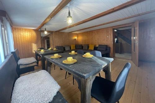 a living room with a table and a couch at 5.5-room apartment (Muntaluna Lodge) in Valens