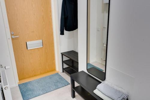 a mirror in a room with a black table and a door at Best location in Tampere! Modern city apartment, 2rooms, kitchen and balcony in Tampere