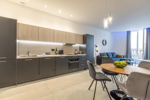 a kitchen with a table and a dining room at Residence Meynadier - apartments - New - AC - Wifi - Close Beach and Palais - LRA Cannes in Cannes