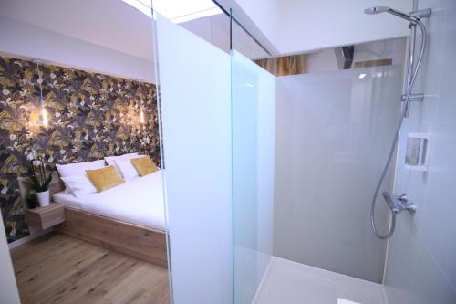 1 dormitorio con 1 cama y ducha acristalada en Chambres4you, en Namur