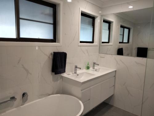 bagno con lavandino, servizi igienici e specchio di Birubi Beach House ad Anna Bay