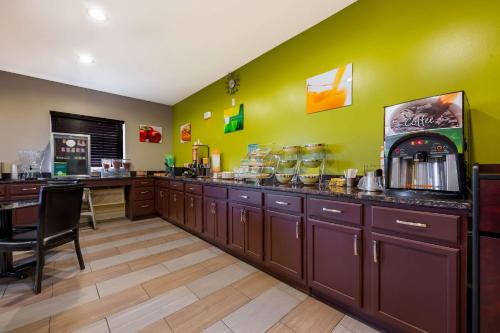 eine Küche mit braunen Schränken und einer grünen Wand in der Unterkunft Quality Inn Fort Payne in Fort Payne