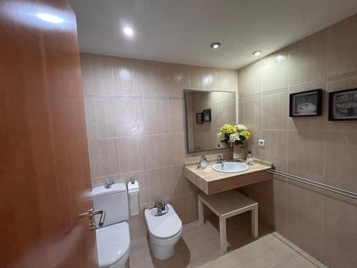 a bathroom with a toilet and a sink and a mirror at APARTAMENTO LOS GIRASOLES 1 in Salou