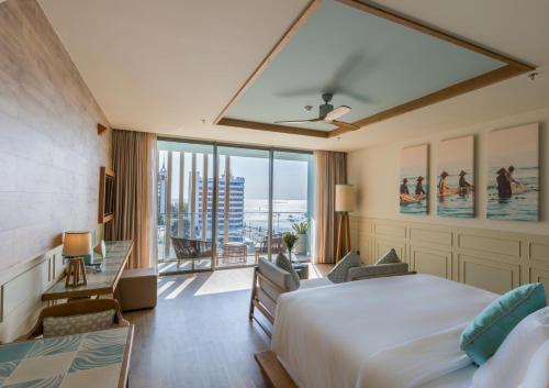 a hotel room with a bed and a large window at Fusion Suites Vung Tau in Vung Tau