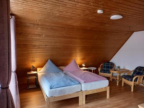 een bed in een kamer met een houten muur bij Ferienwohnungen Aemy in Ostseebad Sellin