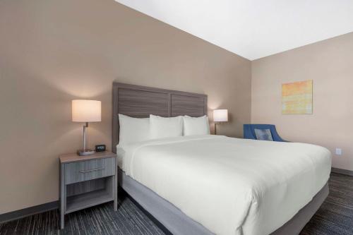 a bedroom with a large white bed and a blue chair at Pestana Orlando Suites - Lake Buena Vista in Orlando