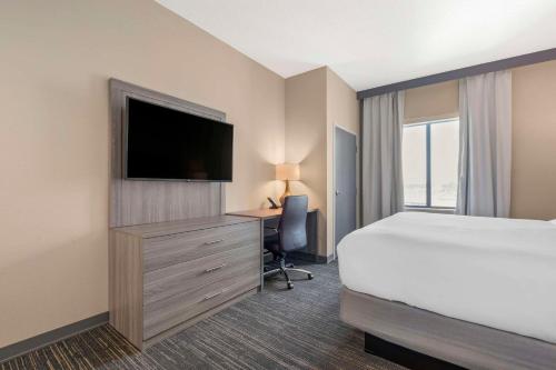 a hotel room with a bed and a desk with a television at Pestana Orlando Suites - Lake Buena Vista in Orlando