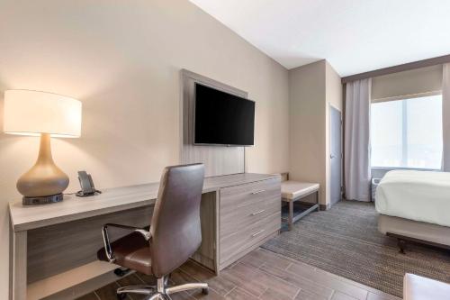 a hotel room with a bed and a desk with a television at Pestana Orlando Suites - Lake Buena Vista in Orlando