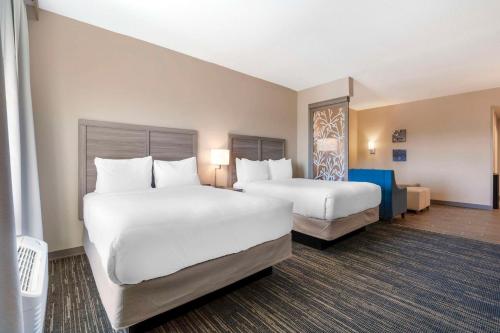 two beds in a hotel room with white sheets at Pestana Orlando Suites - Lake Buena Vista in Orlando