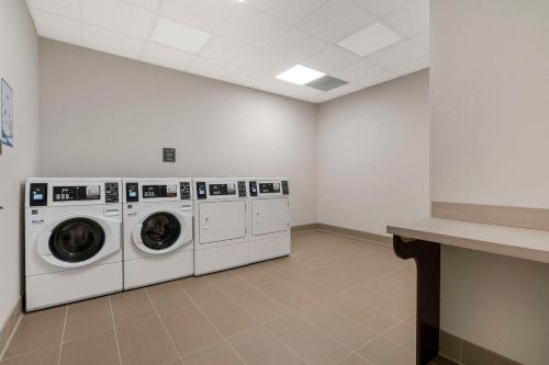 a laundry room with three washing machines and a counter at Pestana Orlando Suites - Lake Buena Vista in Orlando