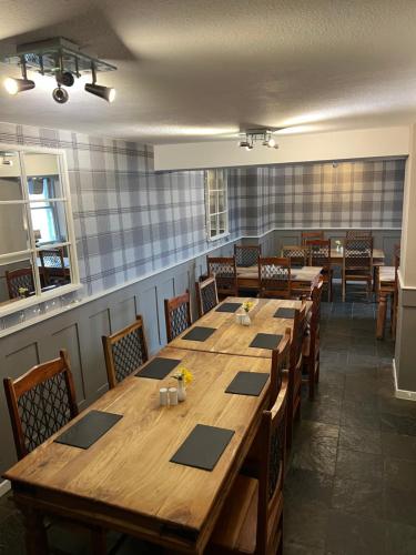 a dining room with a large wooden table and chairs at The White Swan Hotel in Duns