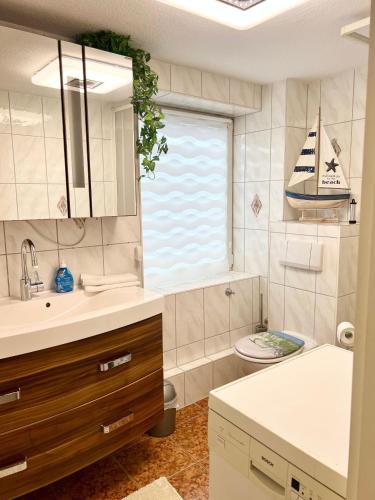 a bathroom with a sink and a boat on the window at Seeadler-Wohnung in Diedrichshagen