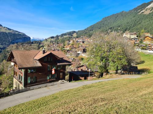 a house on a hill next to a field at Traditional chalet in Wengen - Top Floor in Wengen