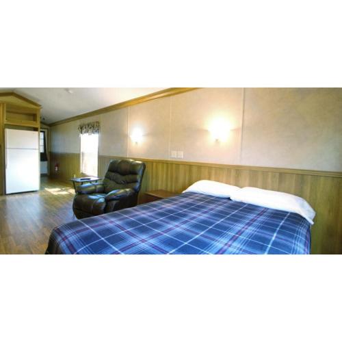 a hotel room with a bed and a chair at JW Coffeyville in Liberty