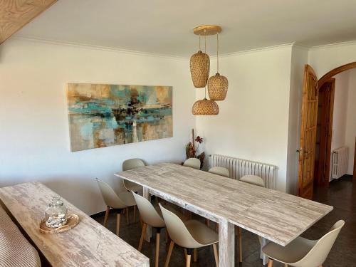 uma sala de jantar com uma mesa de madeira e cadeiras em Villa Begur - Sa Fontansa em Begur