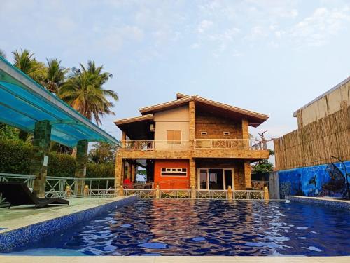 a house with a pool in front of a building at Nahas Beach Resort 