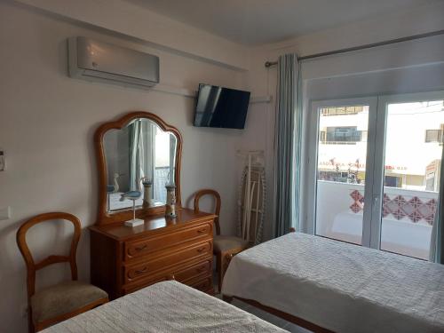 クアルテイラにあるRegueiró Quarteira Beach Apartmentのベッドルーム1室(ベッド2台、鏡、ドレッサー付)