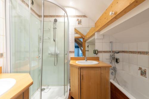y baño con ducha y lavamanos. en Hôtel De La Paix en Gérardmer