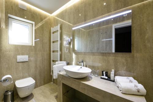 a bathroom with a sink and a toilet and a mirror at Luxury Rooms LaVie - Standard Rooms in Zadar