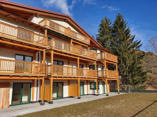 a large apartment building with balconies and a yard at Planaiblick-Lodge Schladming in Schladming