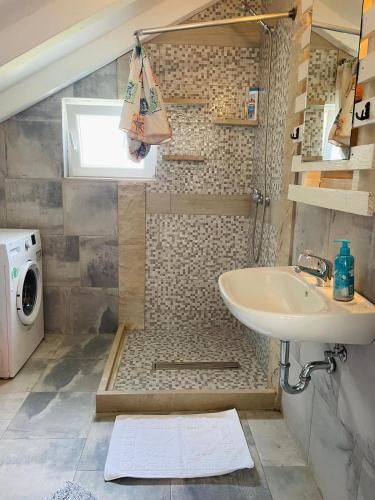 a bathroom with a sink and a washing machine at Villa SARA in Postira