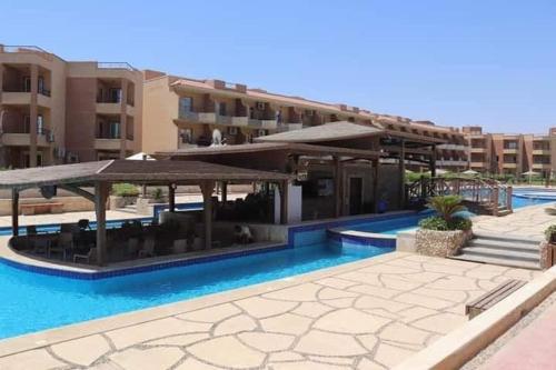 a swimming pool with a pavilion next to a building at شاليه للايجار في قريه لاجولي العين السخنه - للاسر فقط in Ain Sokhna
