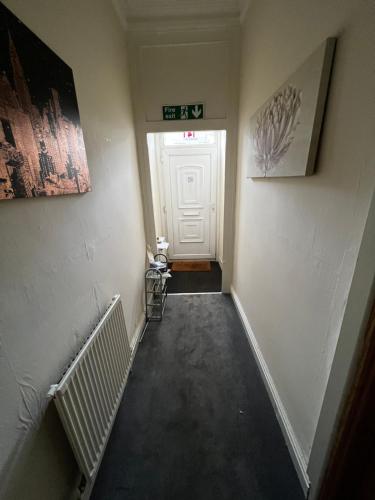 einen leeren Flur mit einer weißen Tür und einer Treppe in der Unterkunft Bury 2 