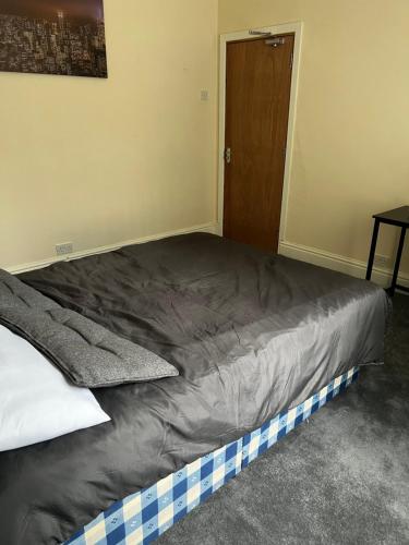 uma cama grande num quarto com uma porta de madeira em Bury 2 