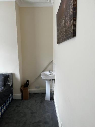 een witte badkamer met een wastafel en een bed bij Bury 2 