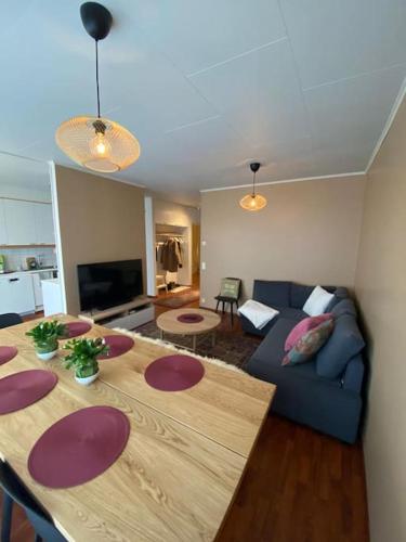 Cozy 73m2 terraced house with sauna في ناتالي: غرفة معيشة مع طاولة وأريكة زرقاء