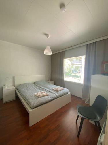 1 dormitorio con 1 cama, 1 silla y 1 ventana en Cozy 73m2 terraced house with sauna en Naantali