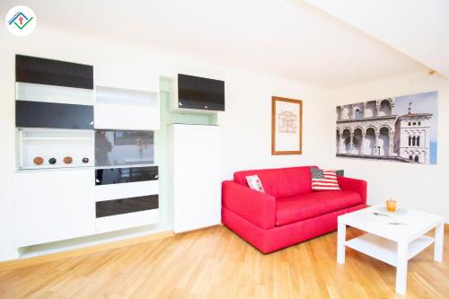 a living room with a red couch and a table at Mezzanino 26 by TuscanyWeGo in Lucca