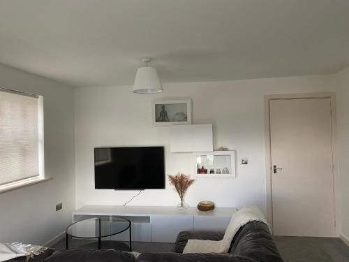 a living room with a couch and a tv on a wall at Marine Viewing 2 bedrooms flat in Manchester