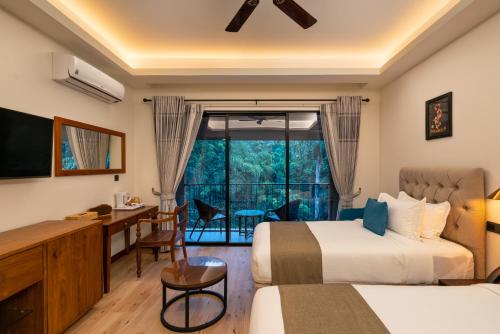 a hotel room with two beds and a desk and a window at Moksha at Kitulgala - Rainforest Boutique Hotel in Kitulgala
