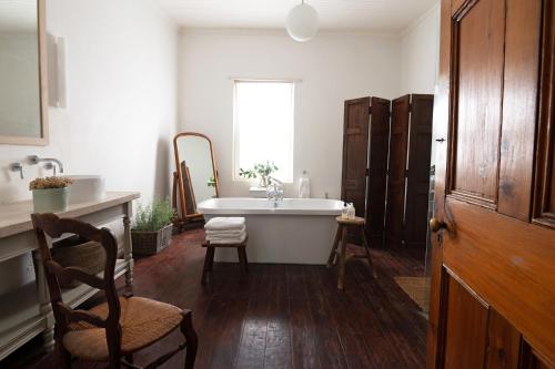 uma casa de banho com uma banheira e um lavatório em Langhuis Guesthouse em Graaff-Reinet