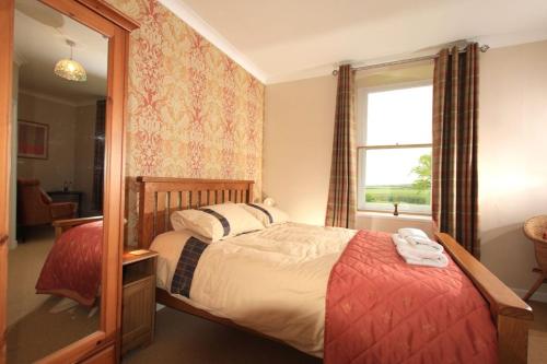 1 dormitorio con cama y ventana en Cuffern Manor, en Roch