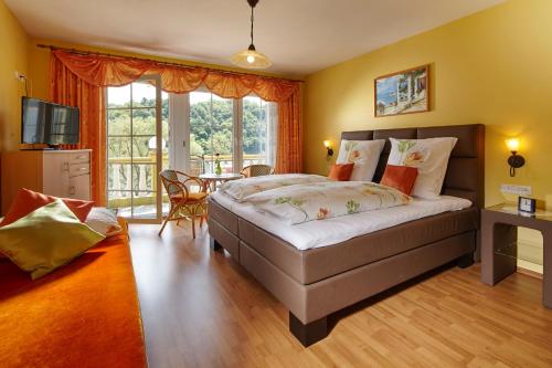 - une chambre avec un lit, une télévision et une table dans l'établissement Panorama Hotel & Restaurant, à Kröv