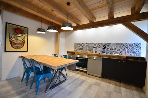 cocina con mesa de madera y sillas azules en L’Etable, en Breitenbach-Haut-Rhin