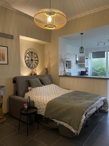 une chambre avec un lit et une horloge au mur dans l'établissement Appartement proche des remparts et tous commerces., à Montreuil-sur-Mer