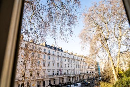 a large white building with cars parked in front of it at Holland House (Victoria) in London