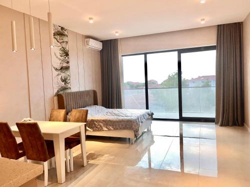 1 dormitorio con cama, mesa y comedor en Apartment in Sea Breeze - Park Residence, en Baku