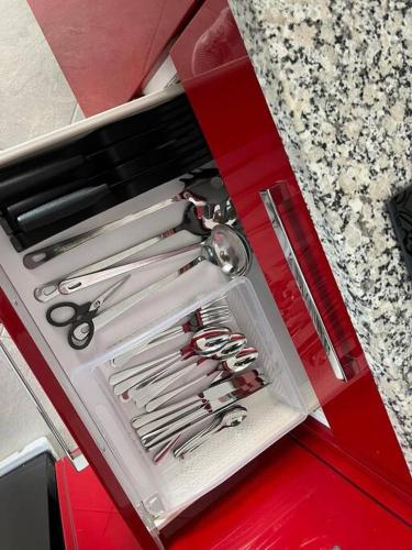a red drawer with scissors and other tools in it at Studio Rouge Cosy à Dar Lili Djerba in Mezraya