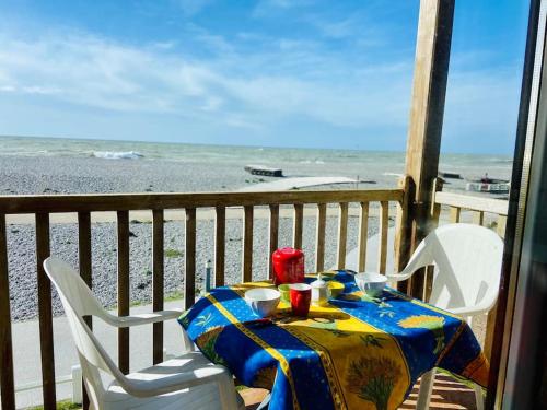 a table on a balcony with a view of the beach at La mer qu’on voit danser…. in Cayeux-sur-Mer