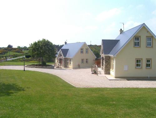 a house with a garage and a driveway at Millstone Cottages in Milford