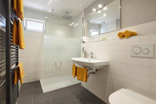 uma casa de banho branca com um lavatório e um espelho em Panorama Hotel & Restaurant em Kröv