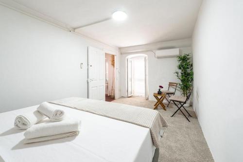 a white bedroom with a bed with towels on it at House Old Town Dubrovnik in Dubrovnik