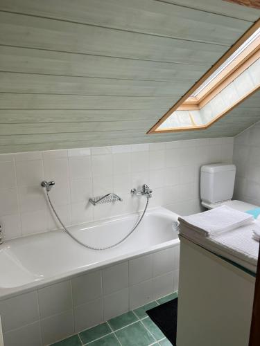 eine Badewanne im Bad mit Fenster in der Unterkunft Chez Tessa - Chambre double in Chamoson