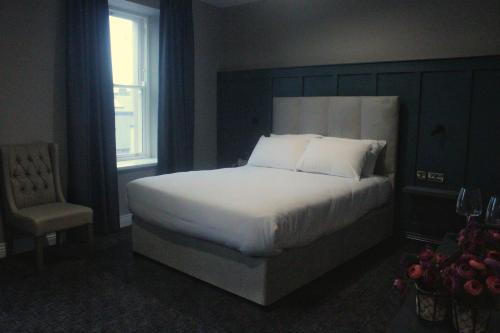 um quarto com uma cama, uma cadeira e uma janela em Pv Fallons em Longford
