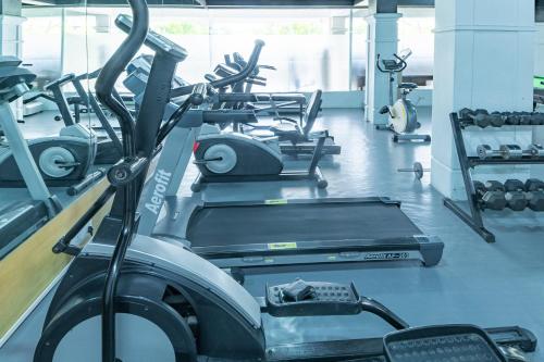 a gym with several rows of treadms and machines at Hotel Athome & Serviced Apartments by Deccan Serai Hotels in Hyderabad