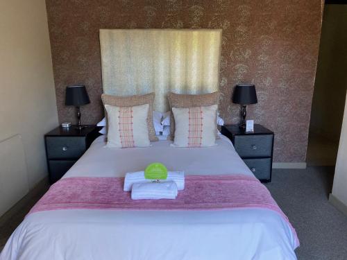 a bedroom with a bed with a green bowl on it at Allegro Guesthouse in Bloemfontein